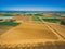 Aerial landscape of plowed fields and crops near ocean coastline.