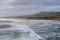 Aerial landscape of sunset over Muriwai beach with waves in the foreground and a typical New Zealand coastal landscape