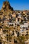 Aerial landscape view of ancient Ortahisar cave city. Blue sky background. Popular travel destination in Turkey