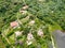 Aerial landscape view of green valley in tropical country with forest, farm field & surrounded by luxury wealthy villa