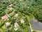 Aerial landscape view of green valley in tropical country with forest, farm field & surrounded by luxury wealthy villa