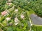 Aerial landscape view of green valley in tropical country with forest, farm field & surrounded by luxury wealthy villa