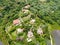 Aerial landscape view of green valley in tropical country with forest, farm field & surrounded by luxury wealthy villa