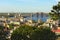 Aerial landscape view of Kyiv during summer sunset. Podil neighborhood and River Dnipro with bridges against blue sky