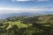 Aerial landscape views on green hills, pastures and the ocean as seen from Lagoa do Fogo Lake/ Lagoon of Fire in direction to