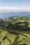 Aerial landscape views on green hills, pastures and the ocean as seen from Lagoa do Fogo Lake/ Lagoon of Fire in direction to