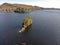 Aerial of a lone island in a seascape sunlit mountain clear ky background