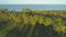 AERIAL Lonely trail runs through perfect green lawn at a tropical golf resort.