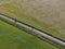 Aerial of meadowland separated by straight bicycle lane with cyclist on the dutch island of Texel