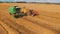 Aerial, modern combine harvesterand tractor working on the wheat field