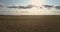 Aerial motion above wheat fields under blue sky with clouds