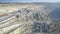 Aerial motion over deep asbestos quarry with mining machines