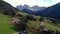 Aerial mountain view of Alpine village, green meadows and pastures, peaks. Dolomiti Alps of South Tyrol