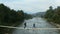 Aerial nature bridge couple running on having fun close small mountain river