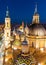 Aerial night cityscape view of the rooftops, towers and spires of the Basilica del Pilar in Zaragoza, Spain