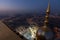 Aerial night shot of the Islamic pilgrimage site surrounded by illuminated buildings in Mecca.