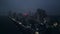 Aerial night view of Colombo skyline, lights flicker along coast, urban landscape under dark sky. Drone flies over Sri