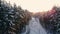 Aerial nordic winter landscape flight over snow mountain forest on sunset.