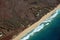 Aerial of Northwest coast of Molokai with waves crashing into Be