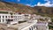 AERIAL: Old Buddhist monastery built into the rocky hill overlooks scenic Tibet.