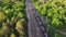 Aerial orbit shot view of railroad with train in sunny summer day in forest. Top view of cargo with industrial products