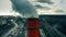 Aerial orbiting shot of a high industrial smoke stack on park and city residential area background