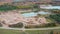 Aerial orbiting shot of an opencast sand, gravel mine quarry full with green water in autumn