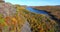 Aerial over cliffs and peak fall forest towards lake up in the mountains