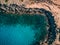 Aerial overhead Rocky seashore with crystal clear blue water near Cape Cavo Greco, Cyprus