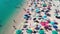 Aerial overhead view of lined beach umbrellas on a tropical beach. Slow motion