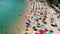 Aerial overhead view of lined beach umbrellas on a tropical beach. Slow motion