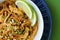 Aerial of Pad Thai Noodles with chicken and lime, blue plate, green table