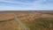 An aerial pamoramic view of the New Forest along a rural road with heartland, forest, pond and wild vegetation with beautiful