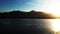 Aerial pan view of lagoon in Inciralti City Forest in Izmir at sunset. Mountains and city view at background