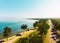 Aerial panning view scenic Sevan lake panorama with pine trees and beach in sunny summer day. Armenia holiday destination.