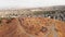 Aerial panning view triangle shape Erebuni fortress ruins on hilltop with Yerevan city panorama background