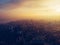 Aerial panorama of dramatic sunset over big city in evening twilight fog or haze, drone view cityscape