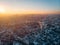 Aerial panorama of dramatic sunset over big city in evening twilight fog or haze, drone view cityscape