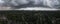 Aerial panorama of heavy dark rain hail thunderstorm clouds over a city.