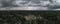 Aerial panorama of heavy dark rain hail thunderstorm clouds over a city.