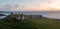 Aerial panorama landscape of the ancient ruins of Dunstanburgh castle at sunrise