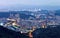 Aerial panorama of overpopulated suburban communities in Taipei at dusk with view of Taipei 101 Tower in downtown & bridges