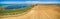 Aerial panorama of plowed field and water pools.