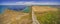 Aerial panorama of plowed field and water pools.