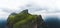 Aerial panorama of a small white lighthouse located on the edge of a huge cliff and the island of Kalsoy. Kalsoy is an