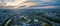 Aerial panorama: Sunrise over river and train tracks through sprawling suburban rural area