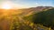 Aerial panorama of sunset over countryside - winding road, fores