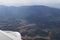 Aerial panorama view from aircraft window show mountains and natural landscape.