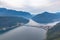 Aerial panorama view of Lugano Lake towards Melide causeway with Swiss Alps mountain Monte San Giorgio on a cloudy summer day from