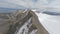 Aerial panorama view natural geology formation textured mountain ridge snowy summit with glacier